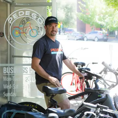 Colin Thomas, standing in front of his e-bike store Pedego Santa Rosa with a fleet of e-bikes