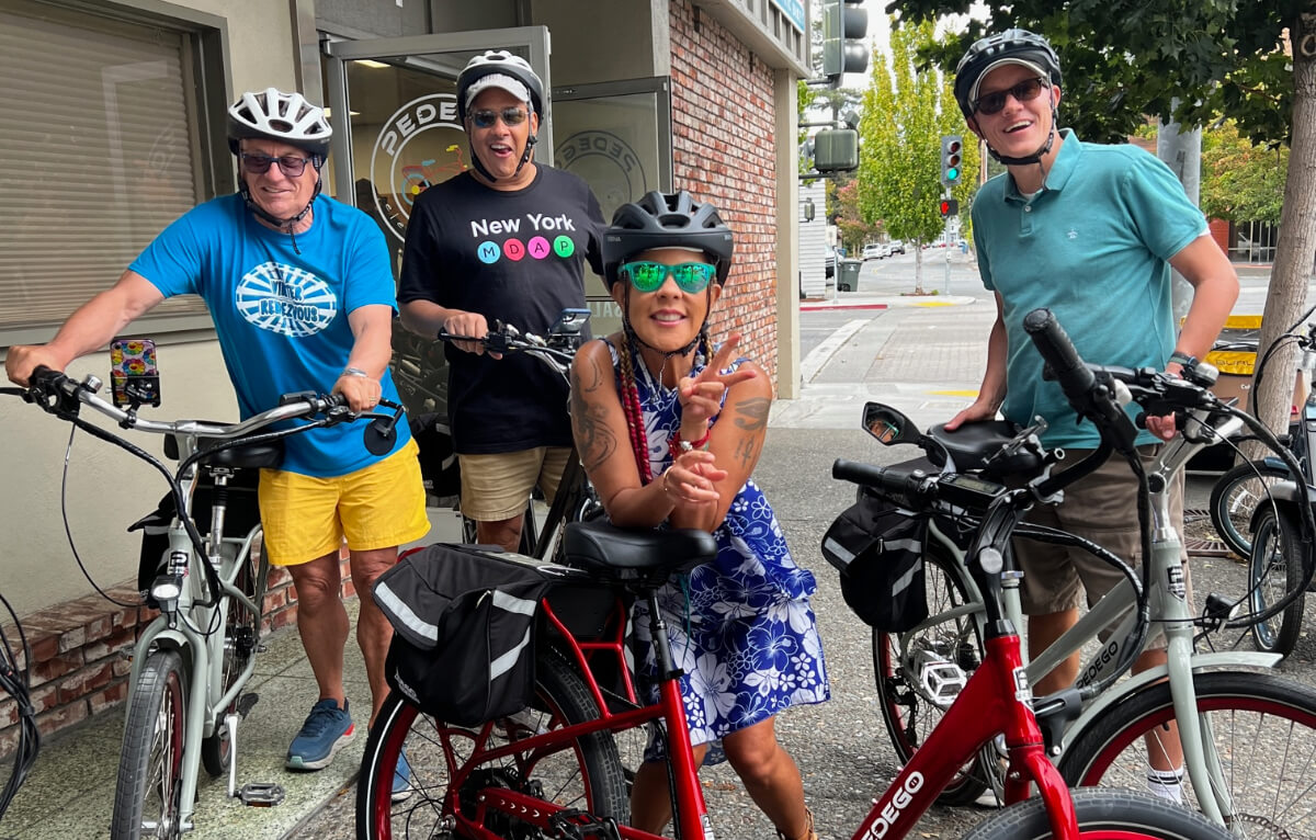 A group of friends smiling with their e-bikes